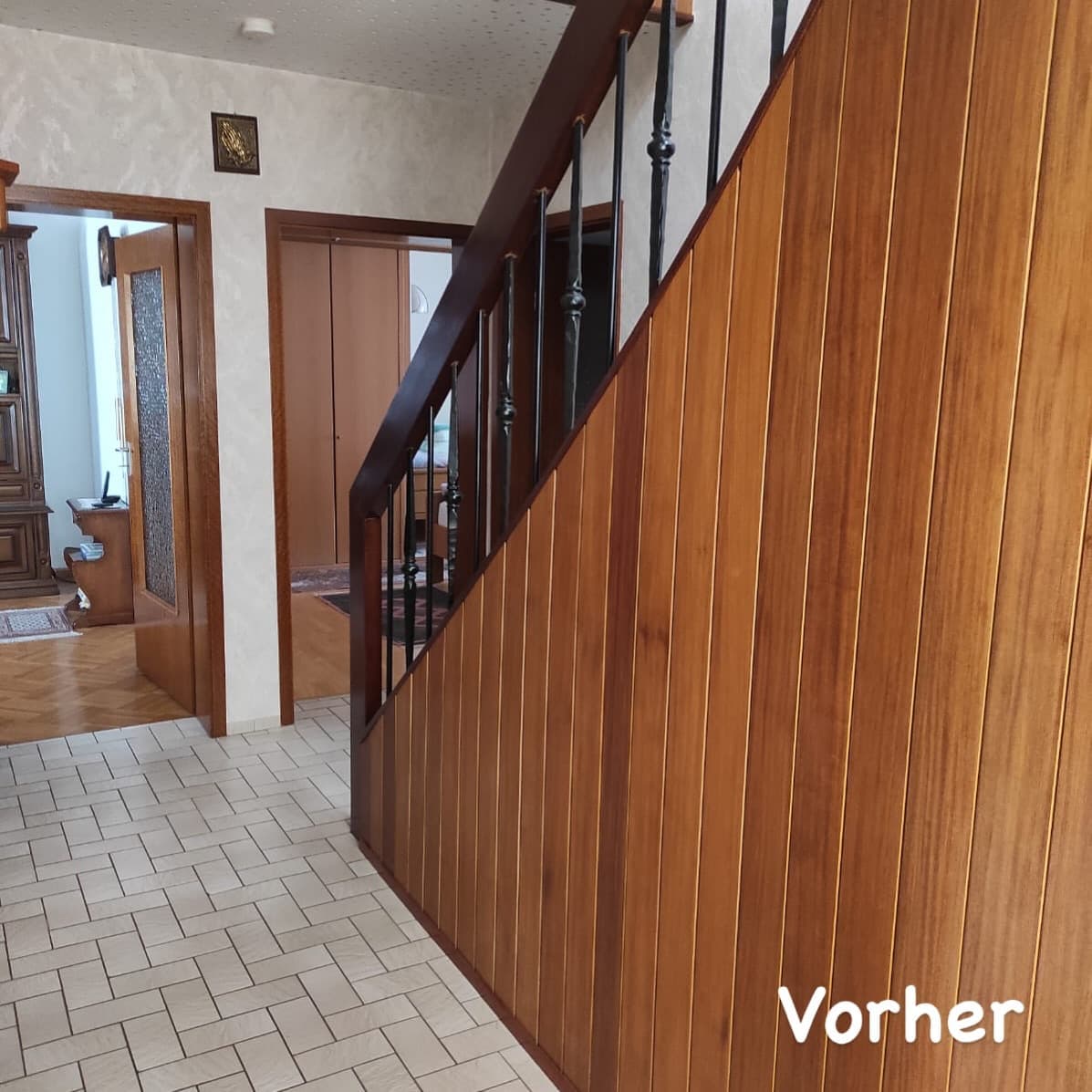 Flur mit alter Holztreppe und Fliesenboden vor der Renovierung
